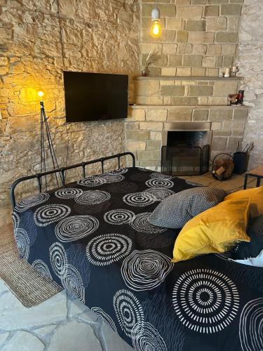 a bed in a room with a brick wall at The Hideaway in Arminou