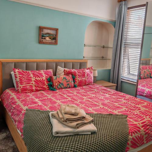 a bedroom with a bed with a red comforter at Ocean City Apartment-with parking in Plymouth