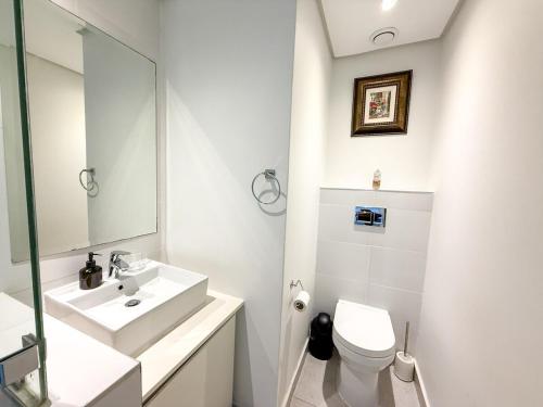 a white bathroom with a sink and a toilet at Luxury 2Bedroom Apart with Ocean & Forest Views in Umhlanga