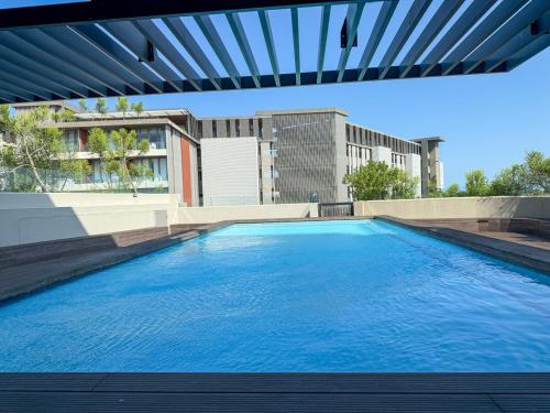 a large blue swimming pool with a building in the background at Luxury 2Bedroom Apart with Ocean & Forest Views in Umhlanga