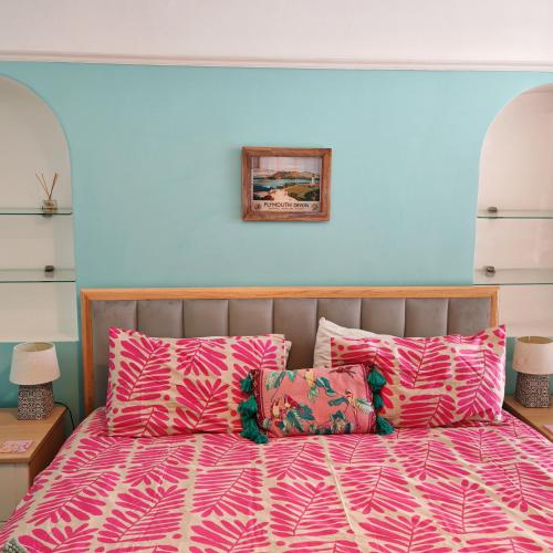 a bedroom with a bed with pink sheets and pillows at Ocean City Apartment-with parking in Plymouth