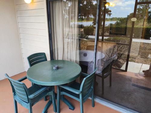a green table and chairs on a patio with a window at Grand Lake & Lifetime of Vacations Resorts in Orlando
