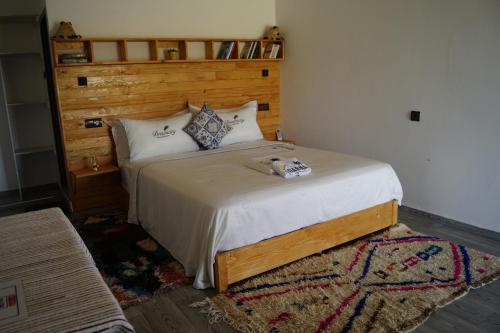 a bedroom with a large bed with a wooden headboard at Darna in Demina
