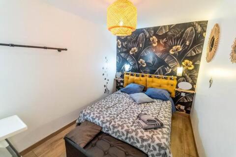 a bedroom with a bed with a painting on the wall at Double Appartement Parking Honfleur 10min plage in Honfleur