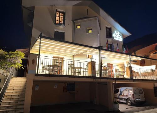 a building with a balcony with tables and chairs at Hotel Ristorante Ligure in Vinadio