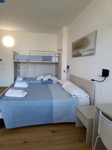 a bedroom with a blue bed and a desk at Edera Hall Inclusive in Cerano d'Intelvi
