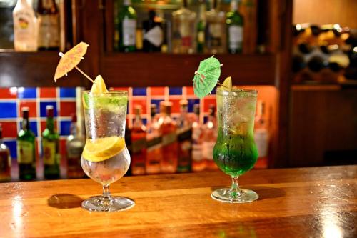 two cocktails sitting on top of a wooden table at Holiday Inn - Bulawayo by IHG in Bulawayo