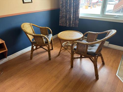 two chairs and a table in a room at Auberg & Motel Moka Creme in Lévis
