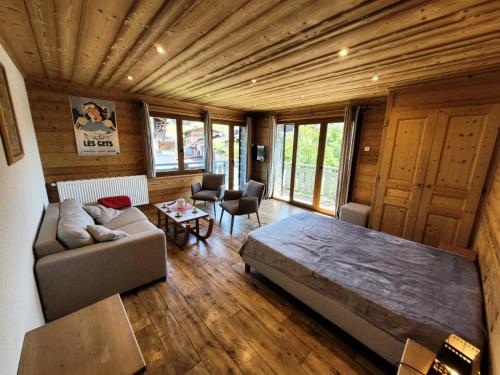 un salon avec un grand lit et un canapé dans l'établissement Résidence Beau Sejour - Appartement confortable, situation centrale MAE-7561, aux Gets