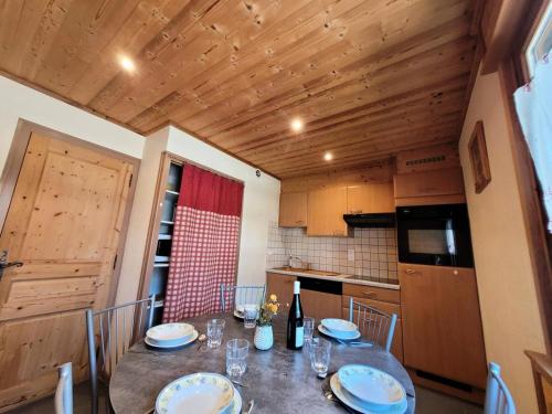 une cuisine avec une table avec des assiettes dessus dans l'établissement Résidence Beau Sejour - Appartement lumineux, proche des piste MAE-7581, aux Gets
