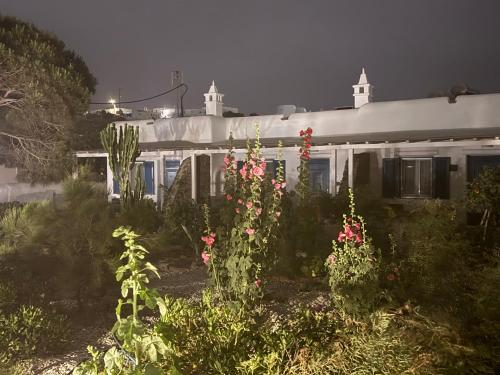 a white house with flowers in the yard at Anais in Mýkonos City