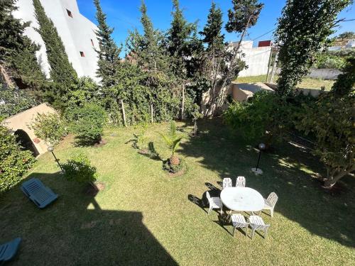 a garden with a table and chairs in the grass at Luxurious, spacious, and family villa in M'diq