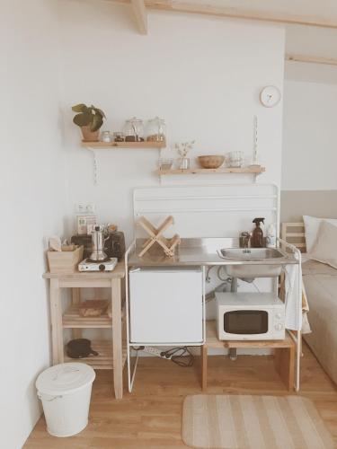 a small kitchen with a table and a microwave at Unique Tiny House close to Ams Airport with Hottub in Rijsenhout