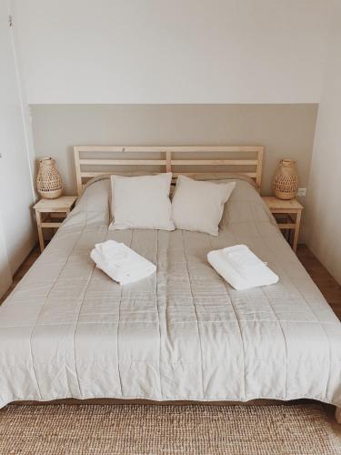 a large bed with two white towels on it at Unique Tiny House close to Ams Airport with Hottub in Rijsenhout