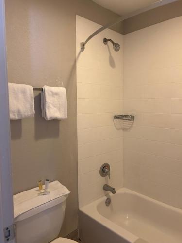 a bathroom with a tub and a toilet and a sink at Days Inn by Wyndham Kingman West in Kingman