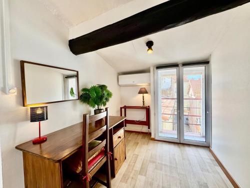 Cette chambre comprend un bureau, un miroir et une fenêtre. dans l'établissement Ostalet Blau Climatisé, à Béziers