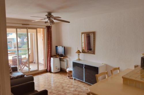 un salon avec un canapé, une table et une télévision dans l'établissement Apartment in the port of Hyères, à Hyères