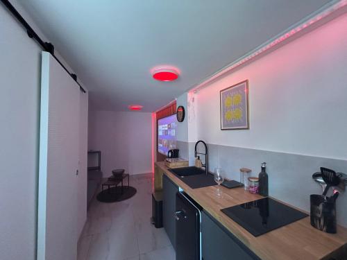 d'une cuisine avec évier et lumière rouge. dans l'établissement Studio Smart & Design - Cannes, à Cannes