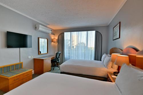 a hotel room with a bed and a desk at Holiday Inn - Bulawayo by IHG in Bulawayo