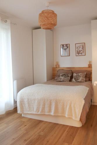 une chambre avec un grand lit avec un panier au plafond dans l'établissement Appartement front de mer Cabourg, à Cabourg