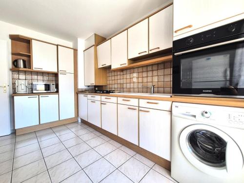 une cuisine avec des armoires blanches et une laveuse et une sécheuse dans l'établissement Residence Du Temple - Très rustique et spacieux appartement ! MAE-4303, à Aix-les-Bains