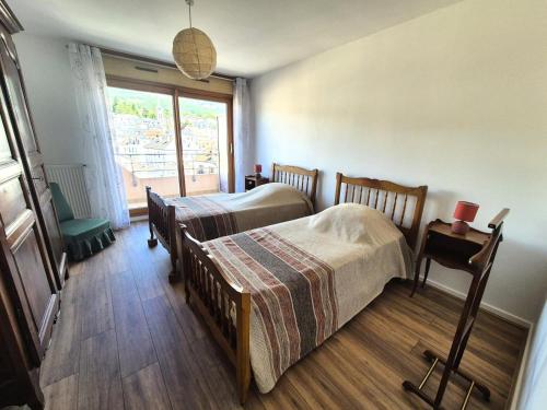 une chambre avec deux lits et une fenêtre dans l'établissement Residence Du Temple - Très rustique et spacieux appartement ! MAE-4303, à Aix-les-Bains