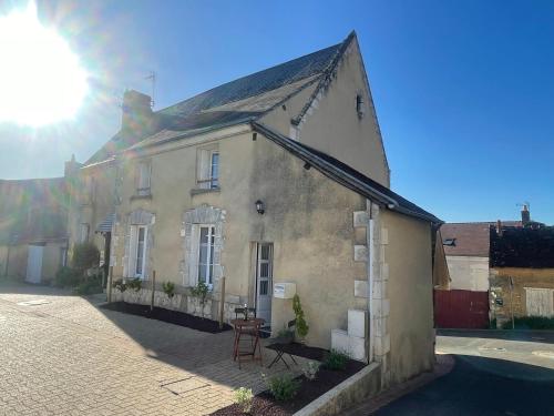 an old house on a street with the sun behind it at Le gîte de Pierrot in Thoré-la-Rochette