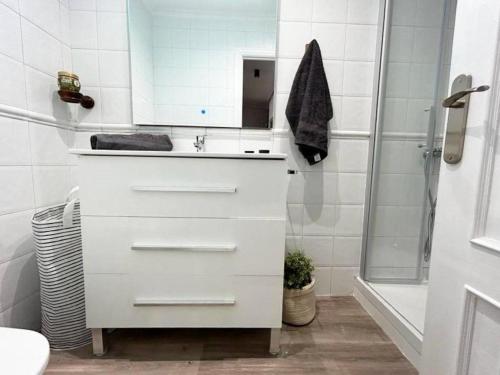 a white bathroom with a sink and a shower at Baiona Curuxa in Baiona