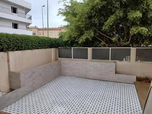 une cour avec un mur et une haie dans l'établissement appartement luxueux laaida, à Sale