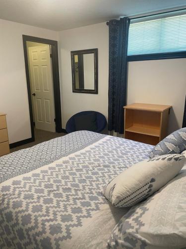 a bedroom with a bed and a window and a chair at Entire Apartment in Guelph
