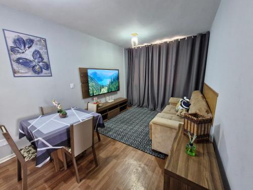 a living room with a table and a couch at Apto no Centro de São Leopoldo in São Leopoldo