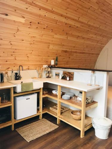 a kitchen with a sink and wooden ceilings at Very unique 'tiny house' with Hottub in Rijsenhout
