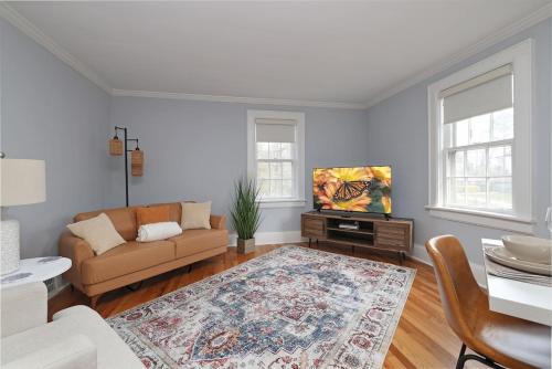 a living room with a couch and a tv at 2nd Level Flat in Durham Lakewood Area in Durham
