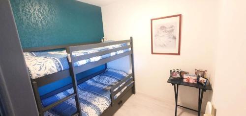 Ce lit superposé se trouve dans un dortoir doté de lits bleus et blancs. dans l'établissement Résidence Drakkar - Ravissant T3 avec terrasse dans domaine avec piscine et tennis MAE-4333, à Six-Fours-les-Plages