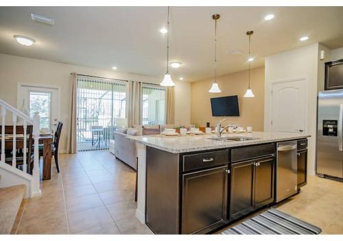 a large kitchen with a large island with a sink at Fabulous 5BR Villa Marvel Private Pool - Solterra Retreat in Davenport
