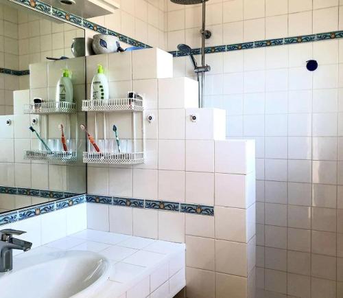 La salle de bains est pourvue d'un lavabo et d'étagères avec des brosses à dents. dans l'établissement Résidence La Calante - Maison avec vue sur les Prés Salés MAE-9821, à La Teste-de-Buch