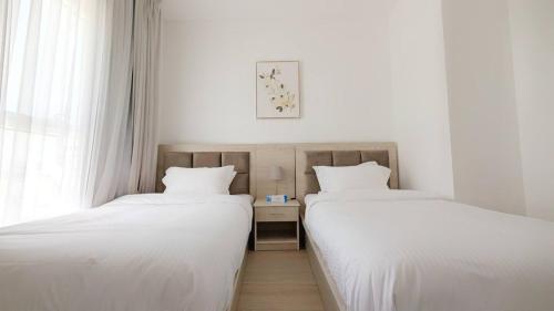 two beds sitting next to each other in a room at Excellent 2br Stay In Yas Island in Abu Dhabi
