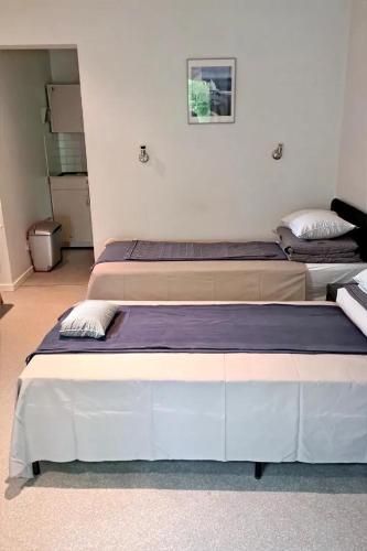 two beds sitting next to each other in a room at Résidence Rachel 23 in Mons