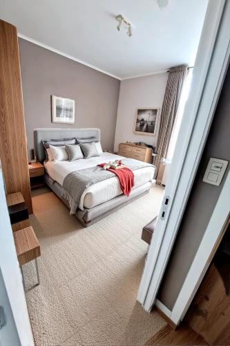 a bedroom with a bed with a red blanket on it at Résidence Rachel 23 in Mons
