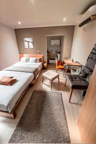 a bedroom with a large bed and a chair at Résidence Rachel 23 in Mons