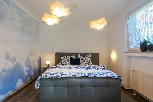 パーダーボルンにあるHimmelsnest Apartment im Zentrum von Paderbornのベッドルーム1室(青と白の掛け布団付きのベッド1台付)