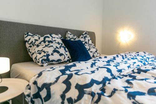 a bed with blue and white sheets and pillows at Himmelsnest Apartment im Zentrum von Paderborn in Paderborn