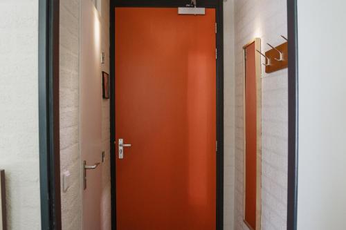 une porte orange dans un couloir dans une pièce dans l'établissement Buitengoed Fredeshiem, à De Bult