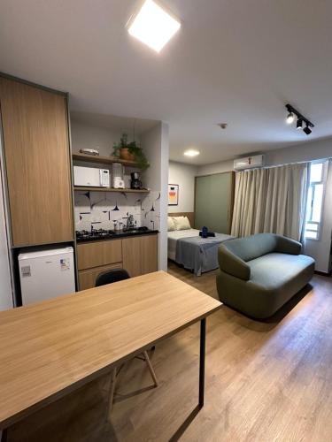 - un salon avec une table, un canapé et un lit dans l'établissement Estúdio Master novo em Brasília, à Brasilia