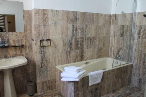 a bathroom with a bath tub and a sink at Les loges de la suite in Prades