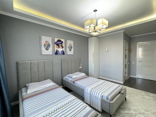 a room with two beds and a chandelier at Botanic Urban Cozy in Astana