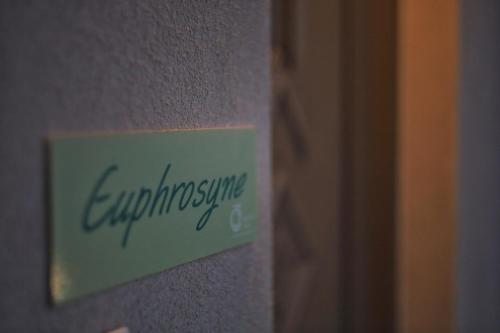 a sign on the side of a wall with the word emulatingine at Three Charites Resort in Gialova