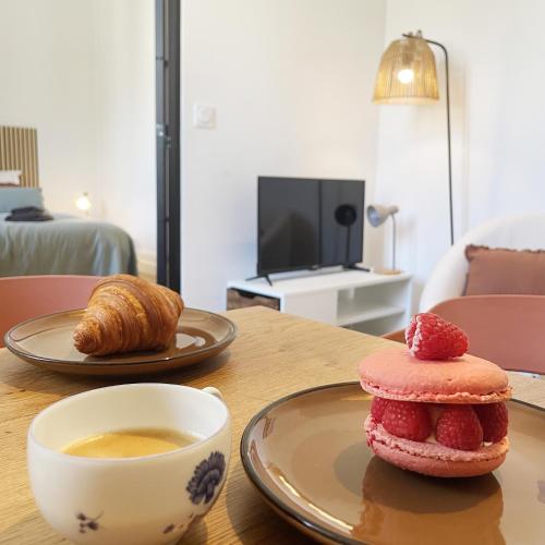 - une table avec une tasse de café et une viennoiserie dans l'établissement Chalet Aux Oiseaux - by La Boite en Plus, à Chantilly