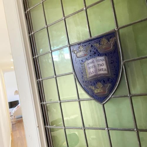 une fenêtre en verre avec une horloge sur un mur dans l'établissement Chalet Aux Oiseaux - by La Boite en Plus, à Chantilly