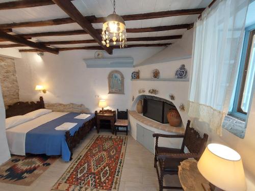 a bedroom with a bed and a tv in a room at Avra traditional Blue house, Elma's Houses in Alonnisos Old Town